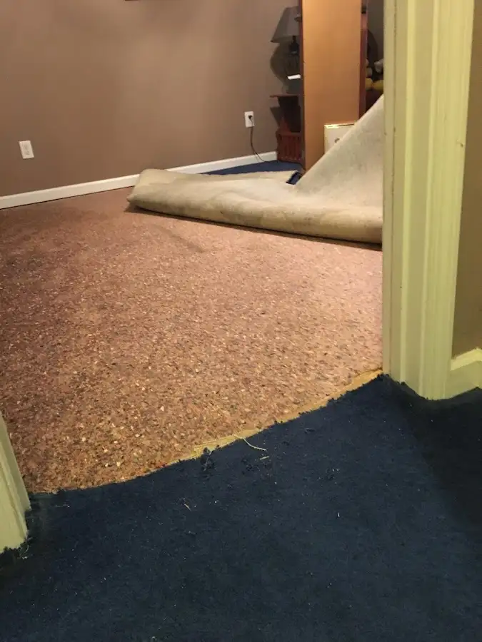 Carpet pad removal revealing water damage during Water Mitigation Services in Panama City Beach